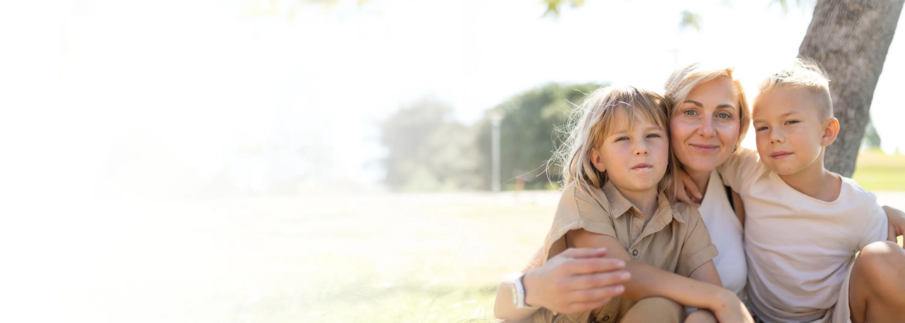 Eine Frau mit zwei Kindern blicken in die Kamera