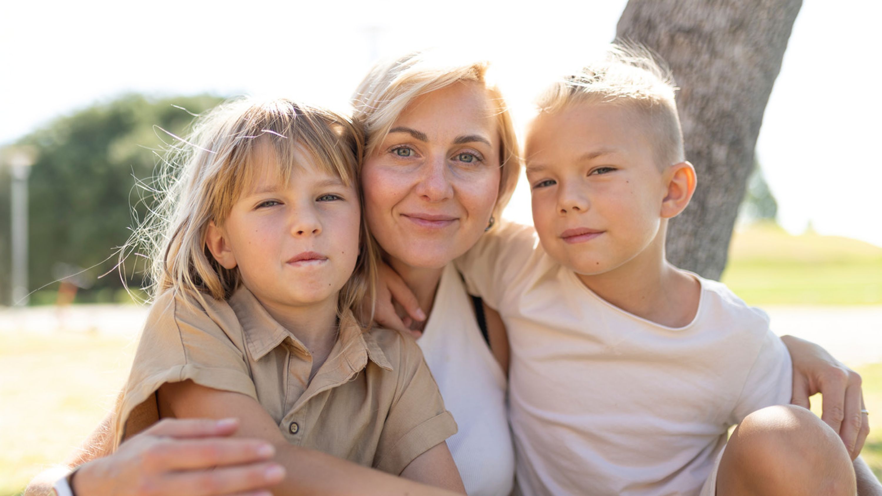 Une femme avec deux enfants regarde l'appareil photo.